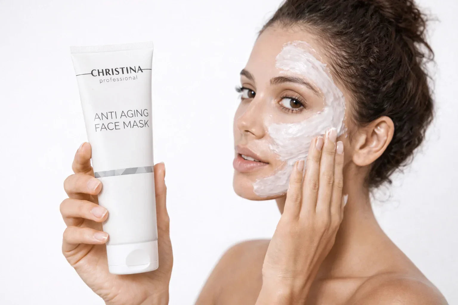 Woman applying anti aging face mask with Christina Professional skincare tube